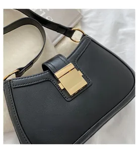 Detail of elegant black leather handbag featuring a secure golden rectangular metal buckle