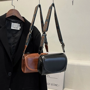 Minimalist crossbody bag in black and brown PU leather with vintage patterned shoulder strap