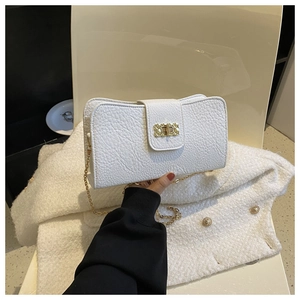 Gros plan d'un petit sac blanc en cuir grainé avec fermoir rotatif doré et bandoulière