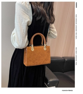 Dettaglio borsa vintage marrone con manico intrecciato e rivetti dorati in metallo