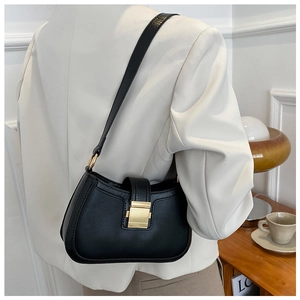 Detailed view of a vintage black leather underarm bag with a golden square metal clasp