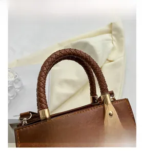 Dettaglio borsa in pelle testa di moro con manico intrecciato e parti metalliche dorate