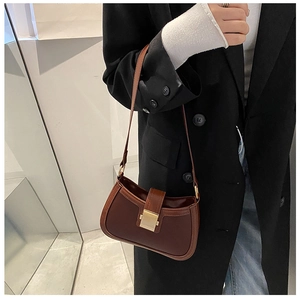 Brown half-moon crossbody bag with golden buckle styled on a black blazer outfit