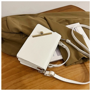 Detail of white litchi pattern leather square bag with gold buckle and accordion folds