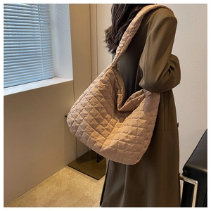 Quilted puffer tote bag in beige shown on model with spacious design for daily travel