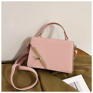 Close-up of pink litchi pattern PU leather handbag with golden heart-shaped twist lock