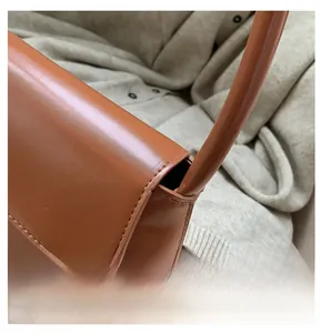 Detailed close-up of precise stitching on the brown leather baguette shoulder bag