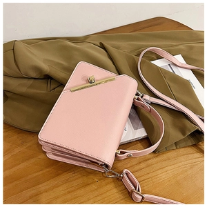 Detail of light pink square crossbody bag showing gold lock and pleated side structure