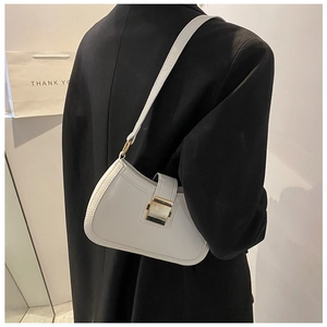 Close-up of white leather underarm bag featuring a vintage gold metal buckle and stitching