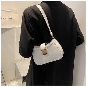 Close-up of minimalist white leather underarm bag featuring a metallic gold square buckle
