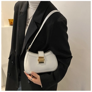 Close-up of white leather underarm bag with gold square metal buckle on black blazer