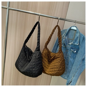 Detailed view of quilted cotton shoulder bags in black and brown on hangers