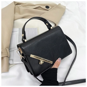 Close-up of black litchi pattern leather bag with gold buckle and top handle detail