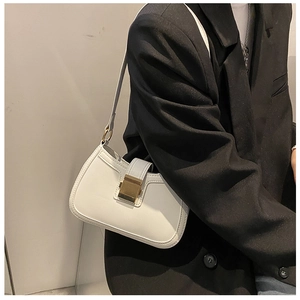 Detail of white leather shoulder bag with gold metal buckle on black blazer