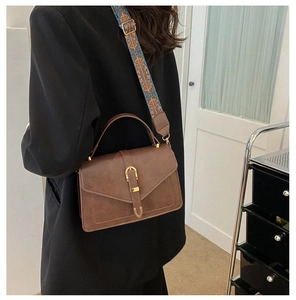 Dettaglio borsa a tracolla marrone vintage con tracolla jacquard colorata e fibbia oro