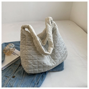 Detail view of the quilted pattern on the white oversized shoulder bag with cotton filling