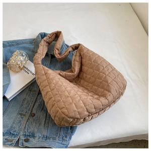 Macro view of brown diamond-quilted puffer bag texture and durable nylon stitching detail