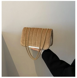 Detail of camel velvet crossbody bag with vertical quilting and gold bead chain strap
