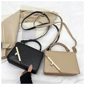 Close-up of sleek rectangular crossbody bags with gold metal bar and twist-lock closure