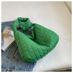 Detail of green quilted puffer hobo bag with diamond stitching on denim jacket