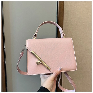 Detailed close-up of pink litchi grain texture bag with gold diagonal metal bar decoration