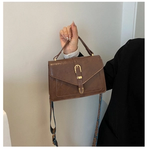 Dettaglio borsa vintage marrone con ampia tracolla con motivo bohémien