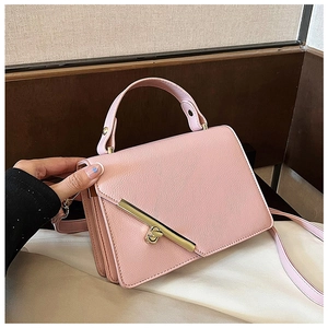 Detailed view of pink crossbody bag with gold metal clasp and accordion side pleats
