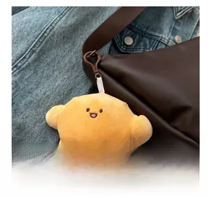 Close-up of a cute yellow star plush charm with embroidery on a brown leather bag