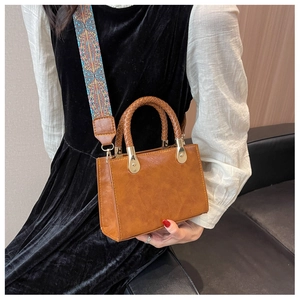 Borsa a tracolla in pelle marrone con ampia tracolla in tessuto a motivi geometrici