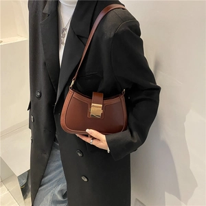 Vintage dark brown underarm bag with gold metal buckle shown on a model