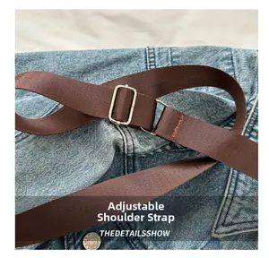 Macro shot of adjustable dark brown textile shoulder strap with a silver metal buckle