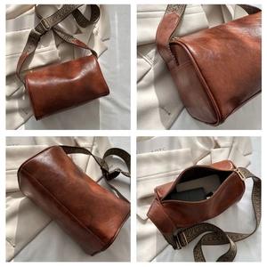 Detailansichten einer braunen Zylindertasche mit Retro-Textur und breitem Webgurt
