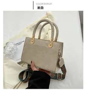Dettaglio borsa a mano bianco crema con manico intrecciato e tracolla ricamata stile etnico