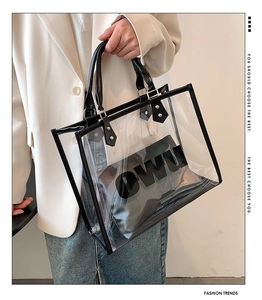 Close-up of a clear PVC tote bag with black leather trim and internal pouch