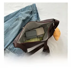Close-up of dark brown crossbody bag showing large capacity with umbrella and wallet
