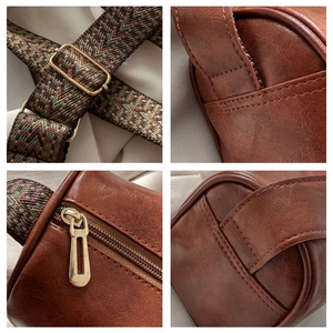 Detailansicht der braunen PU-Tasche mit gewebtem Gurt, Metallschnallen und Nahtstruktur
