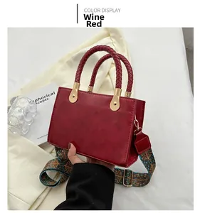 Dettaglio borsa a tracolla rosso vino con manici intrecciati e tracolla etnica
