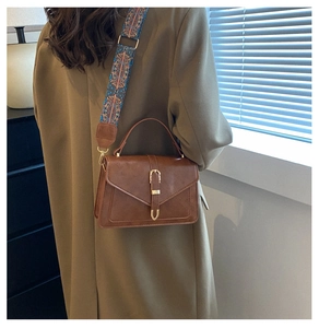 Dettaglio della borsa vintage marrone con tracolla larga intrecciata in stile bohémien