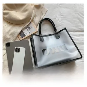 Detail view of the OWU semi-transparent tote bag featuring a reinforced handle and logo