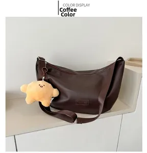 Detail of coffee brown moon bag with leather fashion tag and yellow star pendant