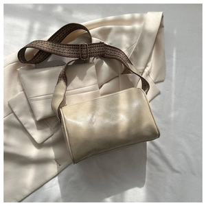 Nahaufnahme einer cremefarbenen Boston Bag mit breitem Stoffriemen im ethnischen Design
