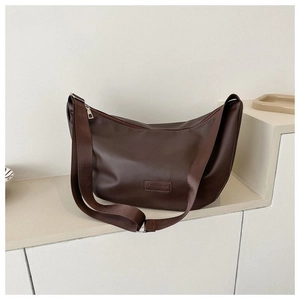 Close-up of a dark brown half-moon hobo bag featuring fashion label and silver zipper
