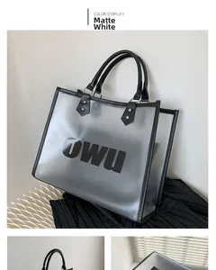 Detail of frosted white transparent tote bag with black handles and OWU graphic