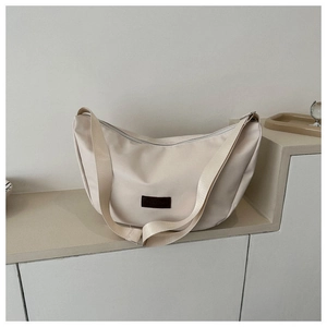 Detail of off-white crescent crossbody bag with minimalist leather fashion label