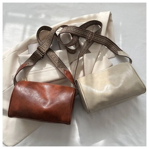 Nahaufnahme von Retro-Zylindertaschen mit breiten Jacquard-Riemen und PU-Leder-Textur
