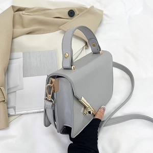 Chic grey lychee texture handbag with gold metal clasp on aesthetic lifestyle background