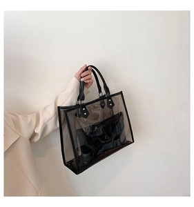 Detail of transparent PVC tote bag with black leather handle and internal pouch