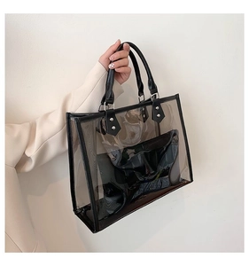 Detail of transparent PVC tote bag with black synthetic leather trim and inner pouch