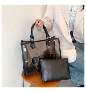 Detail of transparent PVC tote bag with black leather trim and inner pouch