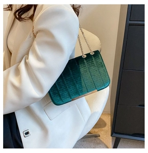 Detailed macro view of dark green velvet handbag featuring vertical quilted texture